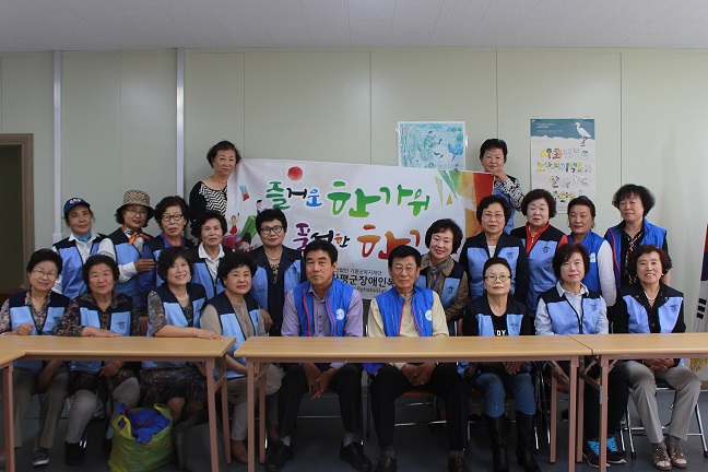 현수막 앞에서 기념촬영하는 자원봉사자들