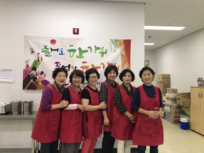 현수막 앞에서 기념촬영하는 자원봉사자들
