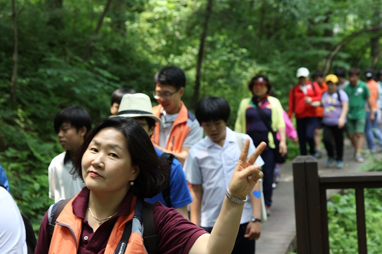 숲길을  걷고 있는 이용자와 보호자들의 모습