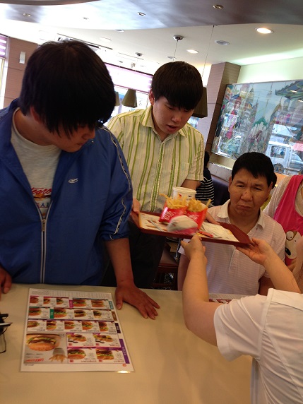 이용자가 패스트푸드점에서 주문한 음식이 나와 전달받고 있는 모습