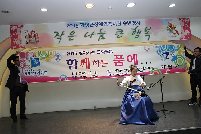 한복을 입고 전통악기를 연주하고 있는 공연자의 모습