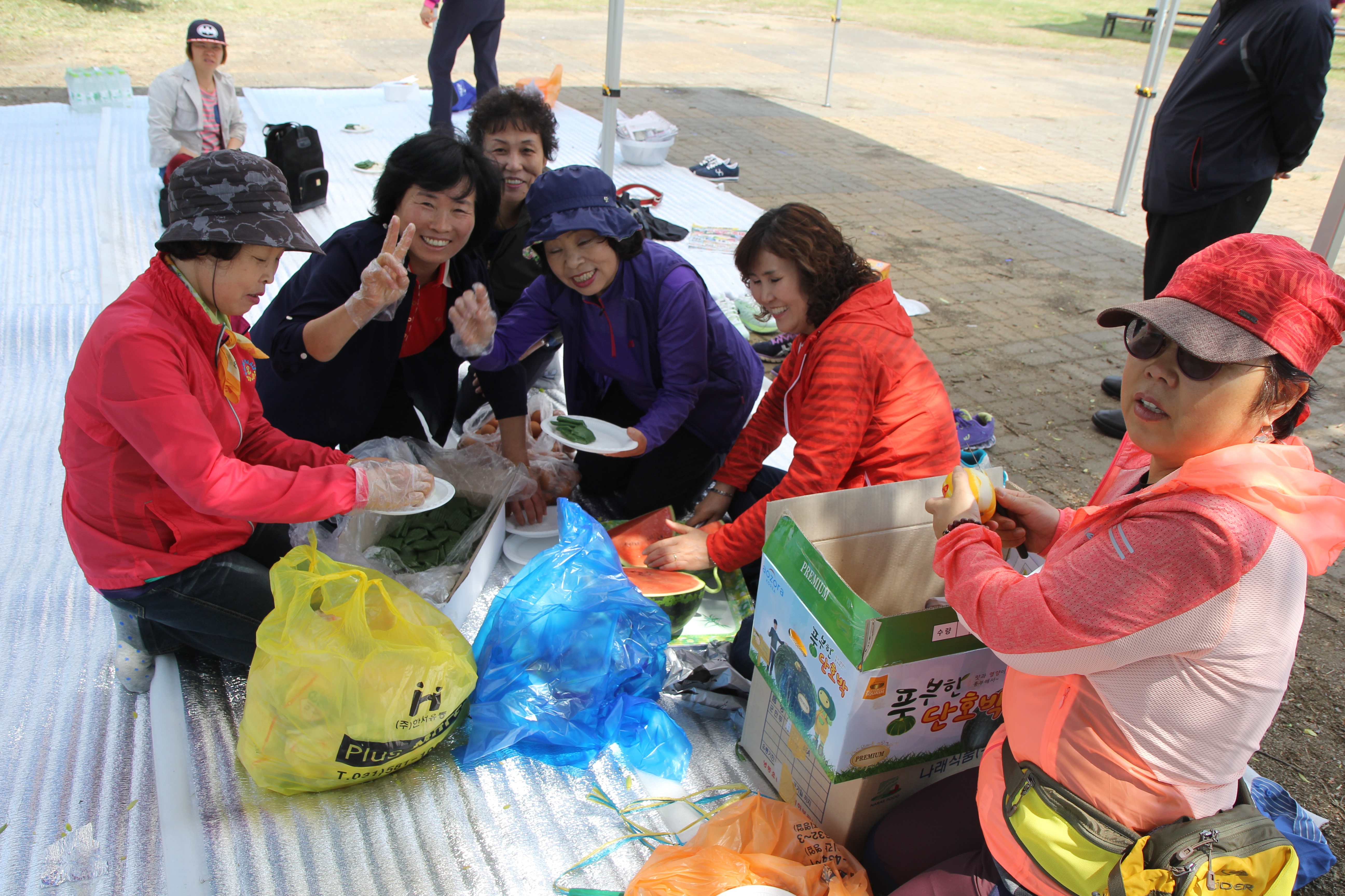 돗자리위에서 점심식사를 준비하고 있는 보호자들의 모습